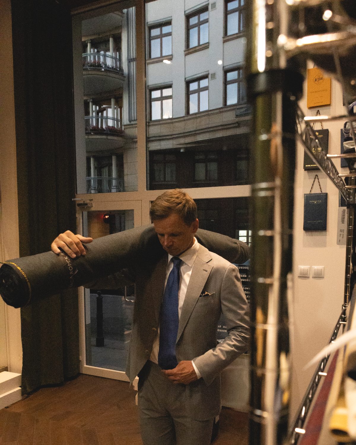 Roman Zaczkiewicz z belą tkaniny w pracowni Zack Roman